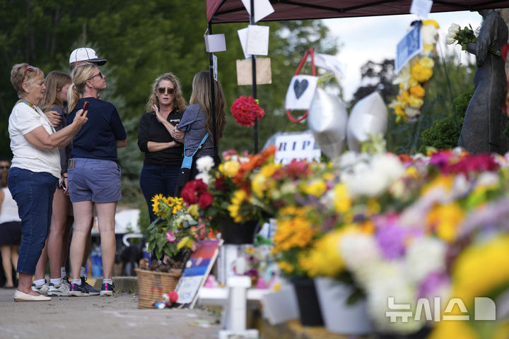[미니애폴리스=AP/뉴시스] 28일(현지 시간) 미국 미네소타주 미니애폴리스의 가톨릭 학교 성당 앞에서 추모객들이 총격 사건으로 숨진 희생자들을 추모하고 있다. 2025.08.29.