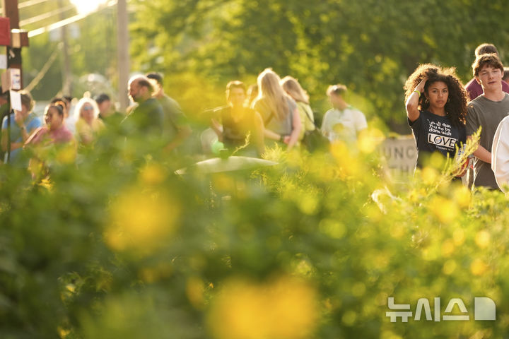 [미니애폴리스=AP/뉴시스] 28일(현지 시간) 미국 미네소타주 미니애폴리스의 가톨릭 학교 성당 앞에서 추모객들이 총격 사건으로 숨진 희생자들을 추모하고 있다. 2025.08.29.