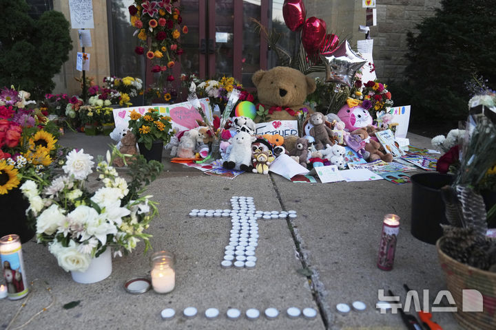 [미니애폴리스=AP/뉴시스] 28일(현지 시간) 미국 미네소타주 미니애폴리스의 가톨릭 학교 성당 앞에 총격 사건으로 숨진 희생자들을 추모하는 물품이 놓여져 있다. 2025.08.29.