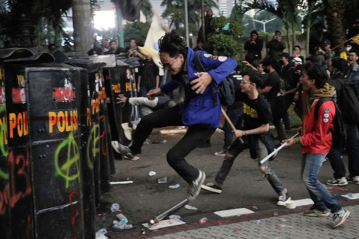 [서울=AP/뉴시스] 29일(현지 시간) 인도네시아 자카르타 경찰청 앞에서 국회의원 수당에 반대하는 시위 중 한 대학생이 배달기사 사망 사건에 항의하며 진압 경찰 방패를 발로 차고 있다. 2025.08.30.