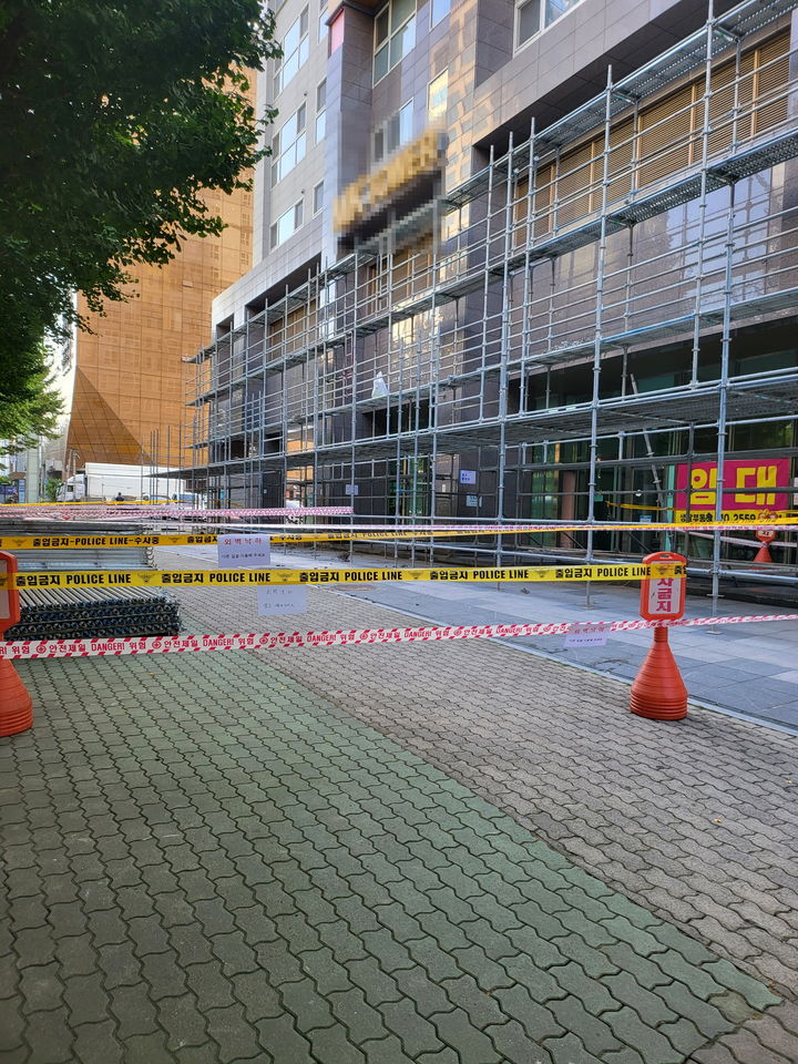 [창원=뉴시스] 지난 23일 오후 경남 창원시 상남동의 한 오피스텔 건물 외벽에서 대리석이 추락해 보행자 통행이 제한되고 있다. 건물 상단에 분홍색 사각형 부분이 대리석이 떨어진 위치. (사진=독자 제공) 2025.08.29. photo@newsis.com *재판매 및 DB 금지