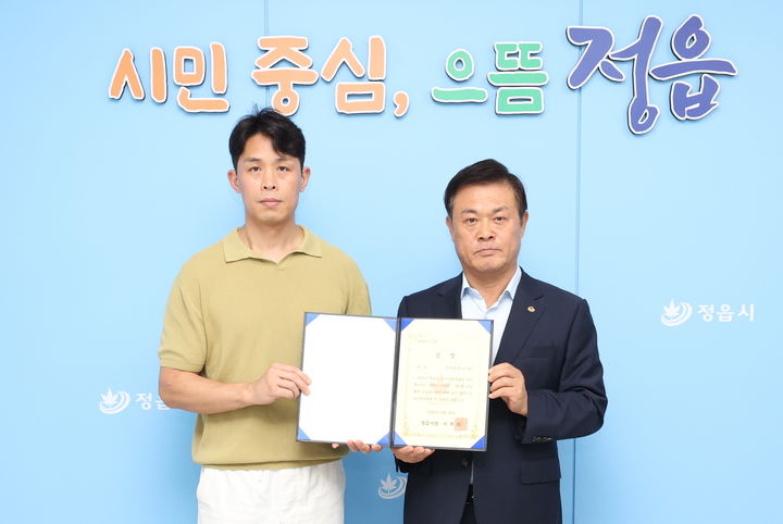 [정읍=뉴시스]29일 정읍시의 제3회 웹툰 공모전에서 작품 '겨울 그리고 겨울'을 출품해 대상을 받은 이규복 작가(왼쪽)와 이학수 시장(오른쪽)이 기념사진을 찍고 있다. *재판매 및 DB 금지