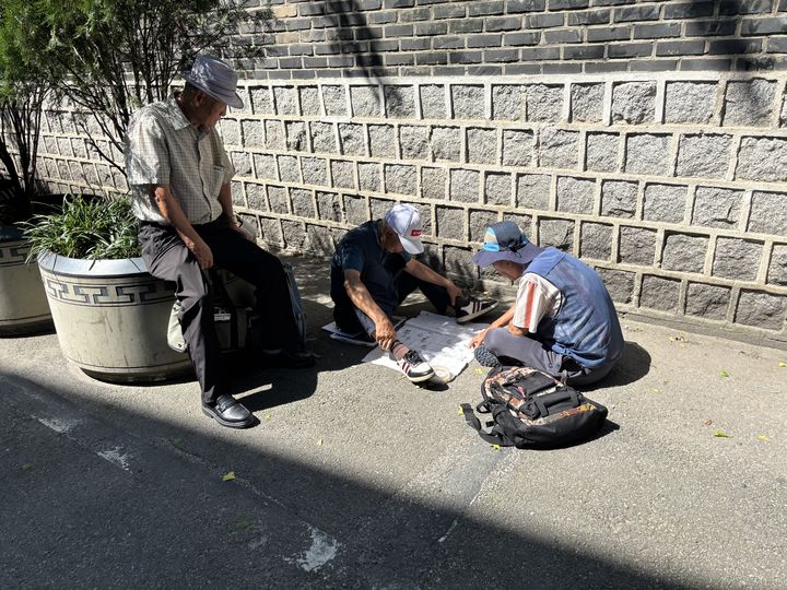 [서울=뉴시스] 서지수 인턴기자 = 서울 종로구 탑골공원에 장기가 금지된 지 한 달이 다 돼가는 29일 오전 일부 인원이 공원 옆 돌담길에서 종이로 만든 장기판을 이용해 수를 겨루고 있다. 서울 종로구청과 종로경찰서는 지난달 31일부터 공원 안팎 오락 행위를 제한했다. 2025.08.31. photo@newsis.com *재판매 및 DB 금지