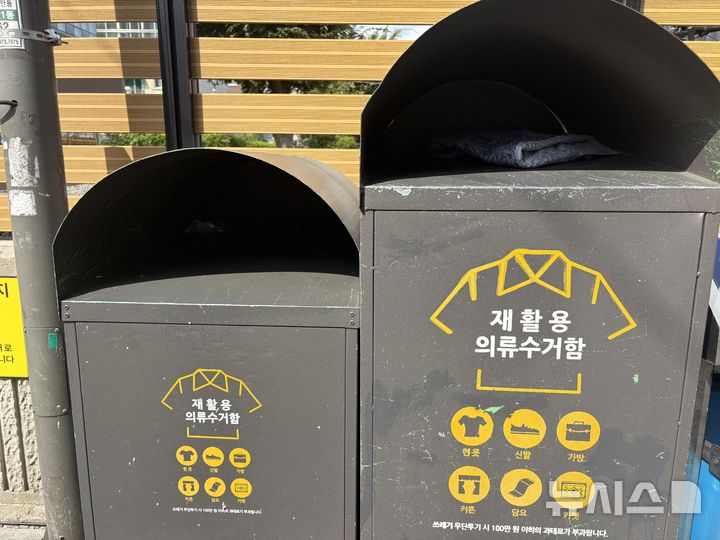 [서울=뉴시스]최은수 기자= 29일 오후 서울 광진구 구의동 주택가에 설치된 의류수거함. 왼쪽(높이 1.3m)은 성인 여성도 팔을 쉽게 넣을 수 있을 정도로 낮고, 오른쪽(1.5m) 수거함은 수거 작업이 제때 이뤄지지 않아 입구까지 옷이 꽉 차 있는 상태다. 2025.08.29