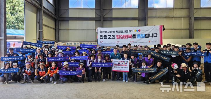 [산청=뉴시스]30일 경남 산청군 산청읍에서 정회숙 경상남도자원봉사센터장이 이승화 산청군수에게 집중호우 피해 주민을 위해 준비한 1억8000만 원 상당의 구호물품 기탁증서를 전달하고, 수해 복구 활동을 펼친 18개 시군 자원봉사센터 관리자, 경상남도여성리더봉사단, 경상남도청년봉사단, 경상남도대학생봉사단 등과 단체사진을 찍고 있다.(사진=경상남도자원봉사센터 제공) 2025.08.30. photo@newsis.com