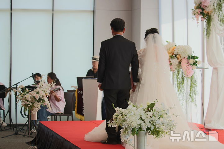 [시흥=뉴시스] 지난 29일 시흥시 관내 솔트베이에서 지역사회공동체가 함께한 '아주 특별한 결혼식'이 열린 가운데 신랑·신부가 입장하고 있다. (사진=시흥시 제공).2025.08.31. photo@newsis.com *재판매 및 DB 금지