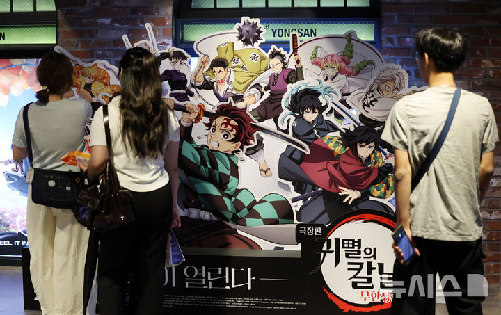 [서울=뉴시스] 조성우 기자 = 일본 애니메이션 영화 '극장판 귀멸의 칼날:무한성편'이 개봉 10일 만에 300만 관객을 넘긴 가운데 31일 서울 시내의 한 영화관에 시민들이 '귀멸의 칼날' 홍보물을 살펴보고 있다.  영화관입장권 통합전산망과 배급사 CJ ENM에 따르면, 지난 22일 개봉한 '극장판 귀멸의 칼날: 무한성편'은 이날 0시 기준 누적 301만2116명 관객을 기록했다. 2025.08.31. xconfind@newsis.com