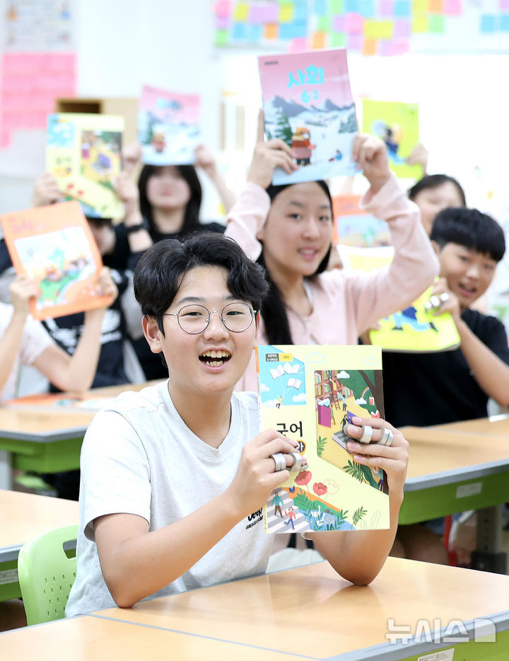 [대구=뉴시스] 이무열 기자 = 여름방학을 마치고 개학한 1일 대구 수성구 대구성동초등학교 6학년 11반 학생들이 새로 받은 2학기 교과서를 들어 보이고 있다. 2025.09.01. lmy@newsis.com