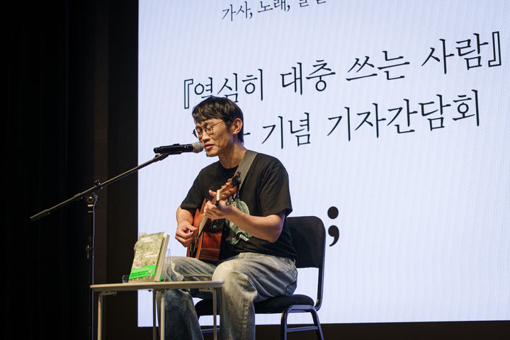 [서울=뉴시스] 브로콜리너마저의 보컬·베이시스트 윤덕원이 작가로 변신했다. 2일 서울 종로구 노무현시민센터 다목적홀 가치하다에서 책 '열심히 대충 쓰는 사람' 출간 기자간담회가 열렸다. 윤덕원은 이날 제목과 동명의 곡을 연주했다. (사진=세미콜론 제공) 2025.09.02. photo@newsis.com *재판매 및 DB 금지