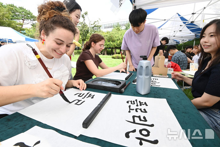 [수원=뉴시스] 김종택 기자 = 2일 경기 수원시 아주대학교에서 열린 동아리 박람회에서 외국인 유학생들이 붓글씨 체험을 하고 있다. 2025.09.02. jtk@newsis.com **기사 내용과 직접 관련 없습니다**