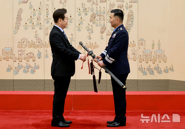 [서울=뉴시스] 최동준 기자 = 이재명 대통령이 2일 서울 용산 대통령실 청사에서 열린 대장 진급·보직 신고 및 삼정검 수치 수여식에서 합동참모의장 후보자인 진영승 전략사령관의 삼정검에 수치를 달아주고 있다. (대통령실통신사진기자단) 2025.09.02. photocdj@newsis.com