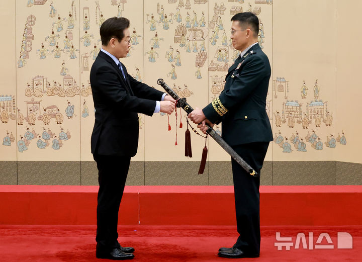 [서울=뉴시스] 최동준 기자 = 이재명 대통령이 2일 서울 용산 대통령실 청사에서 열린 대장 진급·보직 신고 및 삼정검 수치 수여식에서 김규하 육군참모총장의 삼정검에 수치를 달아주고 있다. (대통령실통신사진기자단) 2025.09.02. photocdj@newsis.com