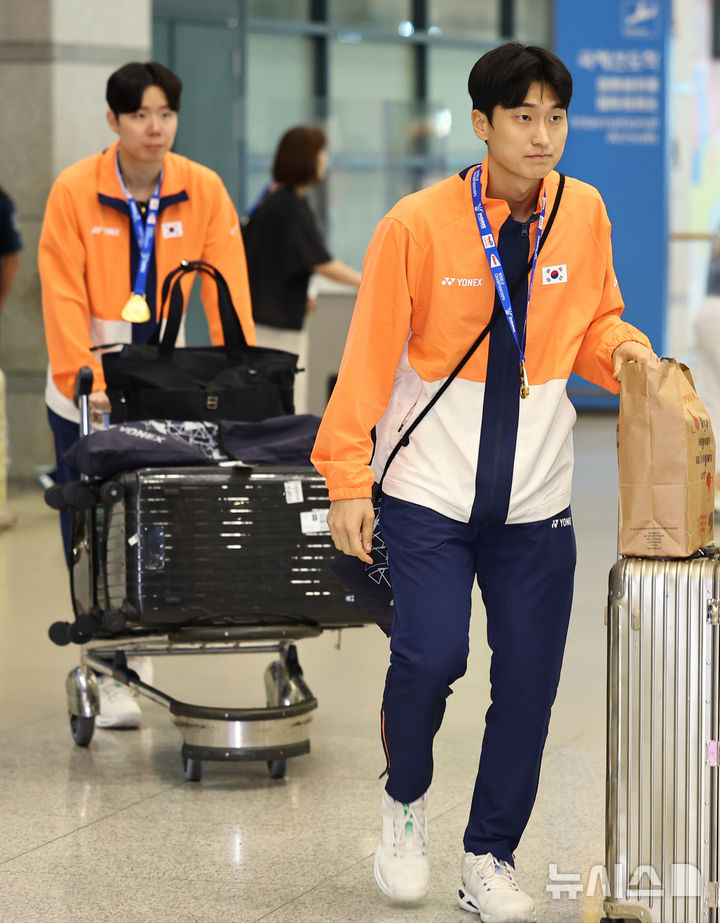 [인천공항=뉴시스] 최진석 기자 = '2025 세계개인배드민턴선수권대회' 남자 복식 정상에 오른 김원호(오른쪽)와 서승재가 2일 오후 인천국제공항 제1터미널을 통해 귀국하고 있다. 서승재·김원호는 지난 1일(한국 시간) 프랑스에서 열린 '2025 세계개인배드민턴선수권대회' 남자 복식 결승전에서 중국의 천보양·류이를 게임 스코어 2-0으로 제압하고 정상에 올랐다. 2025.09.02. myjs@newsis.com