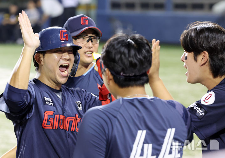 [서울=뉴시스] 배훈식 기자 = 2일 오후 서울 송파구 잠실야구장에서 열린 2025 신한 쏠뱅크 KBO리그 LG 트윈스와 롯데 자이언츠의 경기, 9회초 1사 만루 상황에서 추격의 2타점 적시타를 때려낸 롯데 대타 김민성이 포효하며 동료들의 축하를 받고 있다. 2025.09.02. dahora83@newsis.com