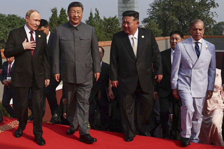 [베이징=AP/뉴시스] 김정은 북한 국무위원장이 3일(현지 시간) 시진핑 중국 국가주석, 블라디미르 푸틴 러시아 대통령과 얘기하며 '중국 인민 항일 전쟁 및 세계 반파시스트 전쟁 승리(전승절)' 80주년 기념 열병식이 열리는 베이징 톈안먼광장에 도착하고 있다. 2025.09.03.