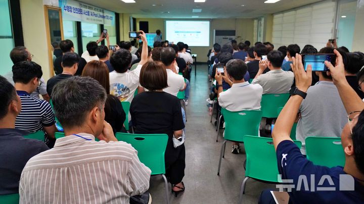 [전주=뉴시스]윤난슬 기자 = 수영장 안전관리 시스템 설명 자료를 사진에 담는 참석자들 모습. (사진=전주시설공단 제공) photo@newsis.com 