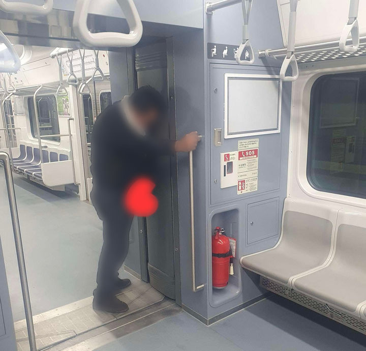 [서울=뉴시스] 지난 2월 지하철 1호선 열차 내부 연결 통로에서 한 남성이 소변을 보는 듯한 모습. (사진=보배드림 갈무리) *재판매 및 DB 금지
