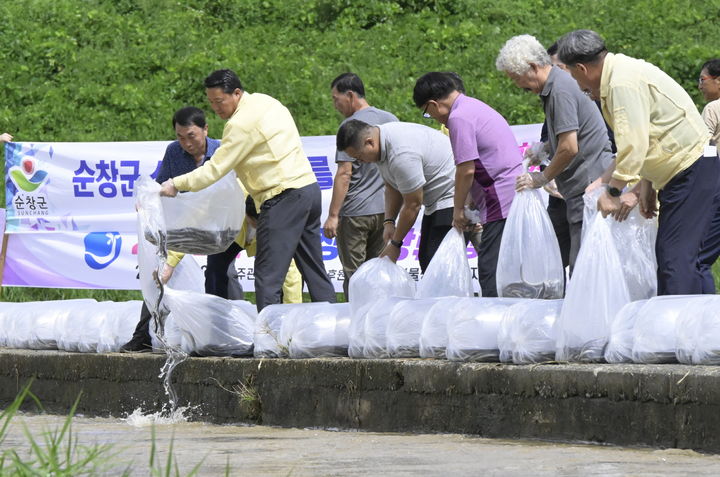 [순창=뉴시스] 지난 2일 순창 섬진강 일원에서 열린 뱀장어 치어 방류행사, 최영일 순창군수(왼쪽 두번째)를 포함한 지역 양만어가들이 15㎝ 이상의 뱀장어 치어를 강에 방류하고 있다. *재판매 및 DB 금지