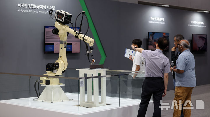 [서울=뉴시스] 김선웅 기자 = 3일 서울 강서구 코엑스 마곡에서 열린 제1회 산업 AI EXPO HD현대그룹 부스에서 방문객들이 HD현대로보틱스의 AI기반 용접불량 제어 시스템을 살펴보고 있다. 2025.09.03. mangusta@newsis.com