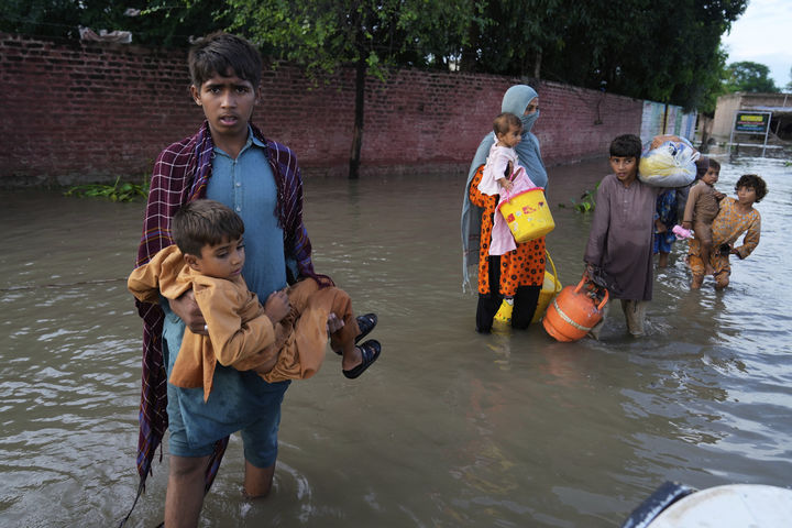 [카수르=AP/뉴시스] 지난달 26일(현지 시간) 수틀레지강 수위가 상승한 뒤 파키스탄 펀자브주 카수르 지역에서 한 가족이 구조보트로 향해 홍수 물을 건너는 모습. 2025.09.18.