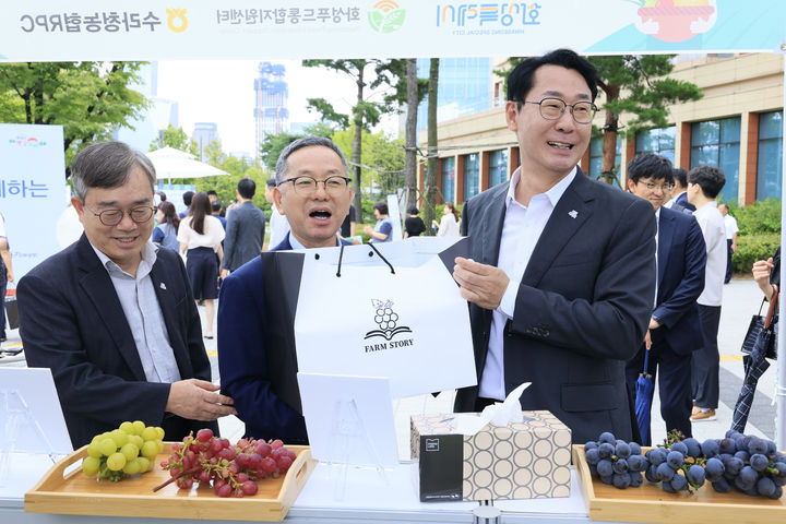 [화성=뉴시스]정명근 화성시장이 4일 국회 로컬푸드 직거래 장터에서 송산포도를 살펴보며 환담을 나누고 있다.(사진=화성시 제공)2025.09.04.photo@newsis.com *재판매 및 DB 금지