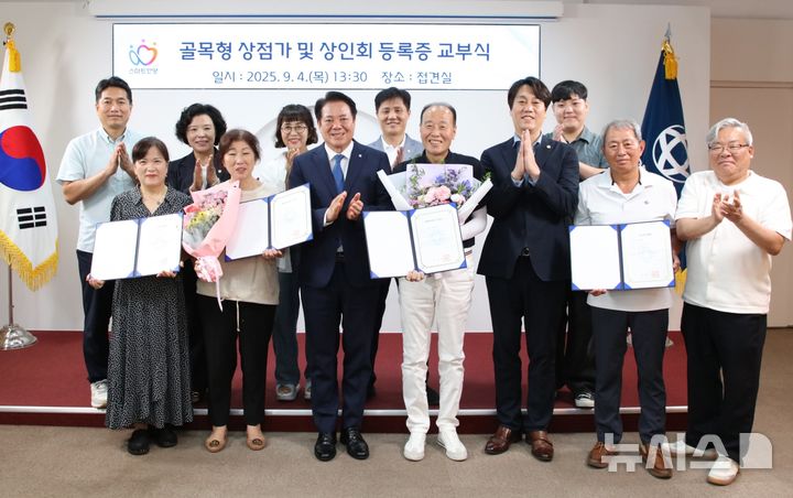 [안양=뉴시스] 골목형상점가 지정 교부식 참석자들이 기념 촬영을 하고 있다. (사진=안양시 제공).2025.09.04.photo@newsis.com