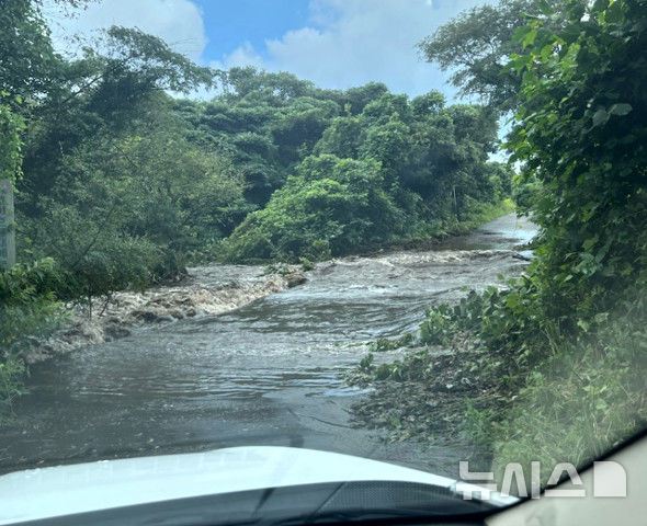 [제주=뉴시스] 5일 오후 3시57분께 제주 서귀포시 표선면 가시리 따라비오름 인근 도로에서 소방당국이 빗물에 고립된 차량을 구조하고 있다. (사진=제주소방안전본부 제공) 2025.09.05. photo@newsis.com 