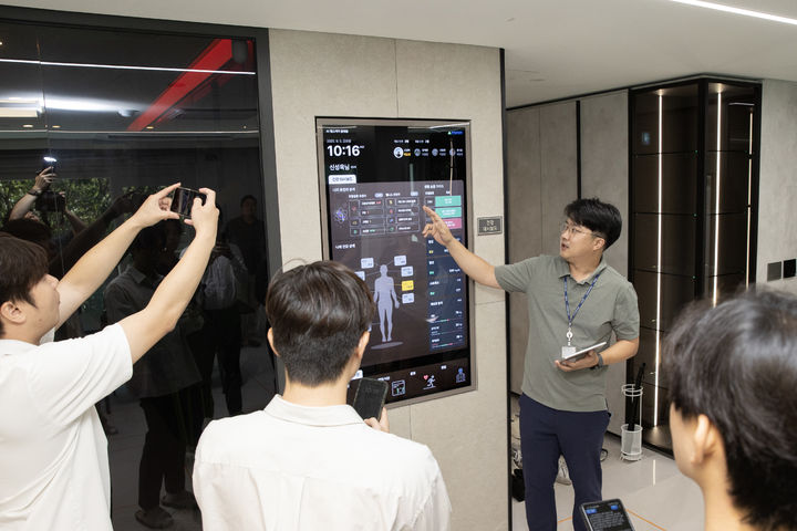 [서울=뉴시스] 현대건설 관계자가 마북기술연구원 '올라이프케어하우스' 내에 있는 건강 대시보드를 보며 유전자 정보에 대해 설명하는 모습. 2025.09.07. (사진=현대건설 제공) photo@newsis.com *재판매 및 DB 금지