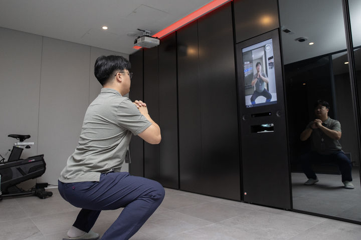 [서울=뉴시스] 현대건설 관계자가 마북기술연구원 '올라이프케어하우스' 내에 있는 '웰니스(Wellness) 솔루션' 중 운동 기능을 직접 시연하는 모습. 2025.09.07. (사진=현대건설 제공) photo@newsis.com *재판매 및 DB 금지