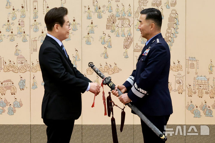 [서울=뉴시스] 최동준 기자 = 이재명 대통령이 2일 서울 용산 대통령실 청사에서 열린 대장 진급·보직 신고 및 삼정검 수치 수여식에서 합동참모의장 후보자인 진영승 전략사령관의 삼정검에 수치를 달아주고 있다. (대통령실통신사진기자단) 2025.09.02. photocdj@newsis.com