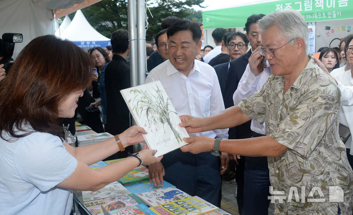 [전주=뉴시스] 김얼 기자 = 문재인(오른쪽) 전 대통령이 5일 전북 전주시 한벽문화관 일원에서 열린 '제8회 전주독서대전'에 참석해 시민들과 책을 살펴보고 있다. 문재인 전 대통령은 평산책방 책방지기로 전주독서대전에 참여했다. 2025.09.05. pmkeul@newsis.com