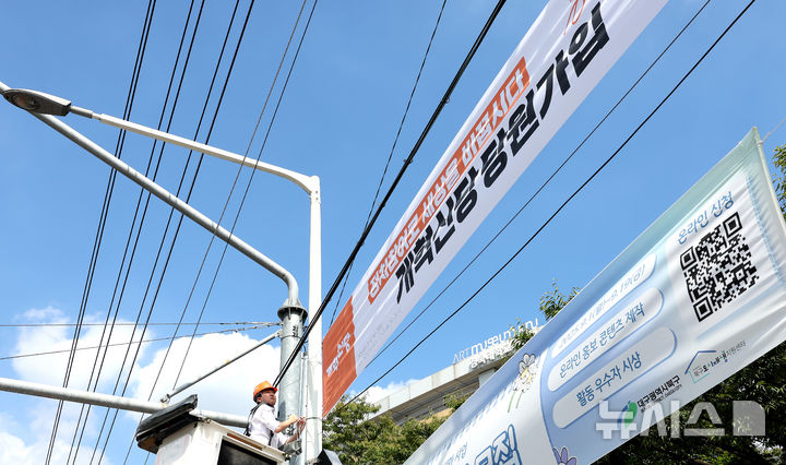 [대구=뉴시스] 이무열 기자 = 이준석 개혁신당 대표가 5일 대구 북구 경북대학교 북문 앞에서 정당 가입 독려 현수막을 직접 게첩하고 있다. 2025.09.05. lmy@newsis.com