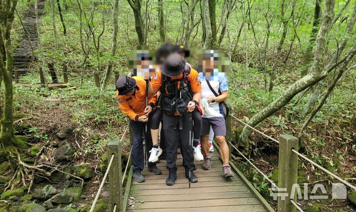 [제주=뉴시스] 6일 오전 제주 한라산 관음사탐방로에서 소방당국이 벌에 쏘인 탐방객을 부축해 이송하고 있다. (사진=제주소방안전본부 제공) 2025.09.05. photo@newsis.com 