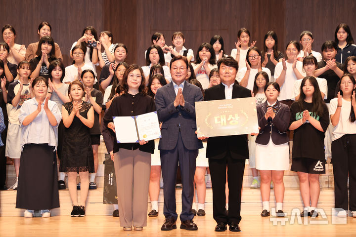 [통영=뉴시스]박완수(가운데) 경남도지사가 6일 통영시 통영국제음악당 콘서트홀에서 열린 사단법인 경남예술문화단체 총연합회 주최·주관 ‘2025년 경남예술제 합창경연대회 동화(同和)'에서 대상을 차지한 통영블루웨이브 합창단에게 시상한 후 기념촬영하고 있다.(사진=경남도 제공) 2025.09.06. photo@newsis.com