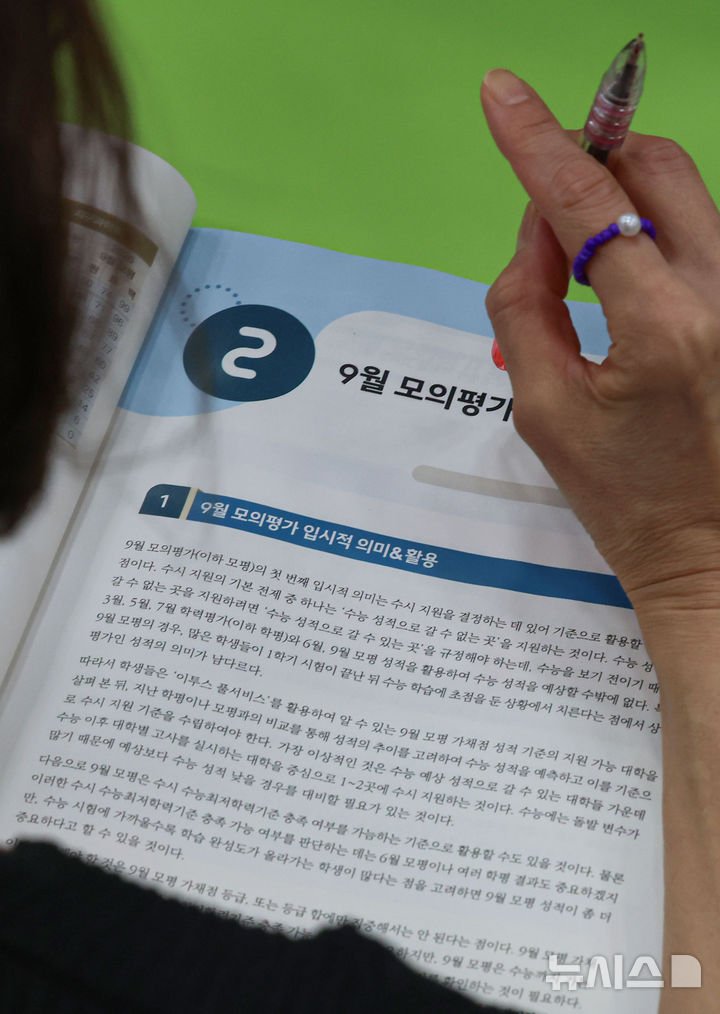 [서울=뉴시스] 권창회 기자 = 6일 서울 강남구 강남하이퍼학원 본원에서 열린 '9월 모의평가 분석설명회에서 학부모들이 9월 모평 분석집을 살펴보고 있다. 2025.09.06. kch0523@newsis.com