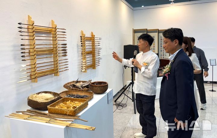 [포항=뉴시스] 송종욱 기자 = 3~13일 경주세계문화대공원에서 ‘경북도 무형유산대전–깊은 울림, 장인의 시간'이 열린 가운데 포항의 궁시장 김병욱·침선장 조정화 장인이 지역 무형 유산의 가치를 널리 알리고 있다. 사진은 김 궁시장이 배진석 경북도의회 부의장에게 화살을 설명하는 모습. (사진=포항시 제공) 2025.09.07. photo@newsis.com