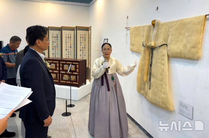 [포항=뉴시스] 송종욱 기자 = 3~13일 경주세계문화대공원에서 ‘경북도 무형유산대전–깊은 울림, 장인의 시간'이 열린 가운데 포항의 궁시장 김병욱·침선장 조정화 장인이 지역 무형 유산의 가치를 널리 알리고 있다. 사진은 조 침선장이 배진석 경북도의회 부의장에게 두루마기 도포를 설명하는 모습. (사진=포항시 제공) 2025.09.07. photo@newsis.com