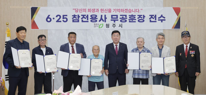 [청주=뉴시스] 이범석 충북 청주시장(왼쪽 다섯 번째)이 8일 임시청사 직지실에서 6·25전쟁 참전용사 유족에게 화랑무공훈장을 전수하고 있다. (사진=청주시 제공) 2025.09.08. photo@newsis.com *재판매 및 DB 금지