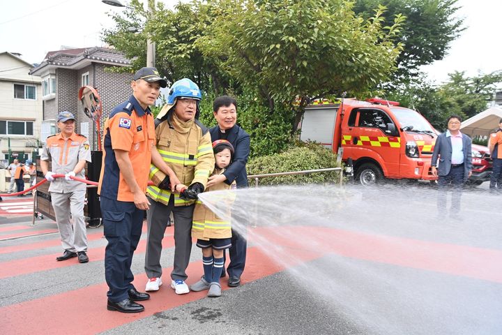 [하남=뉴시스] 이현재 경기 하남시장이 소방 관계자의 안내에 따라 비상소화장치 사용법을 시연하고 있다. (사진=하남시 제공) 2025.09.09. photo@newsis.com *재판매 및 DB 금지