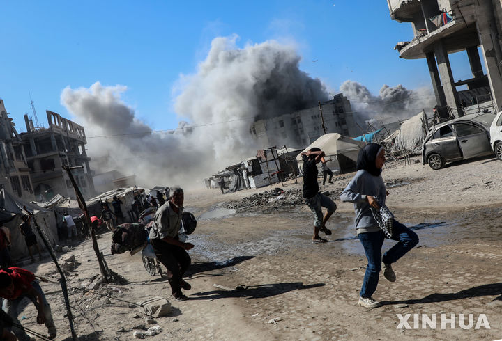 [가자시티=신화/뉴시스] 가자시티의 팔레스타인 주민들이 지난 8일(현지 시간) 시내 14층 고층빌딩에 대한 이스라엘군의 폭격으로 빌딩이 무너지자 연기와 파편을 피해서 달아나고 있다. 2025.09.11.