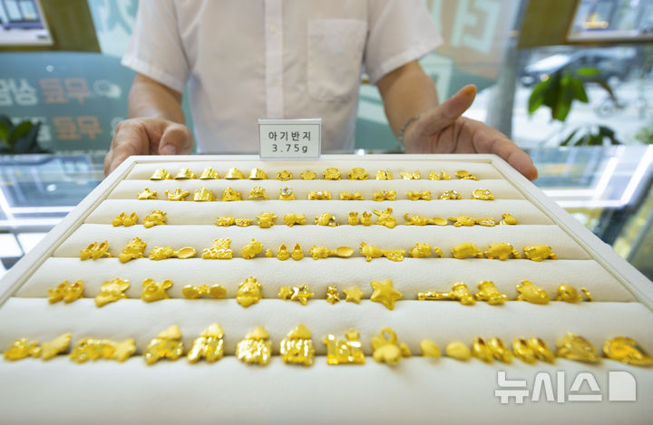 [서울=뉴시스] 김근수 기자 = 9일 서울 종로구 한국금거래소에서 직원이 아기 돌반지를 들어보이고 있다.&nbsp; 최근 금 가격이 급등하면서 금융업계 일각에서는 미국 기준금리 인하 기대만으로도 연말에는 온스당 4천달러에 이를 수 있다는 전망이 나왔다. 2025.09.09. ks@newsis.com