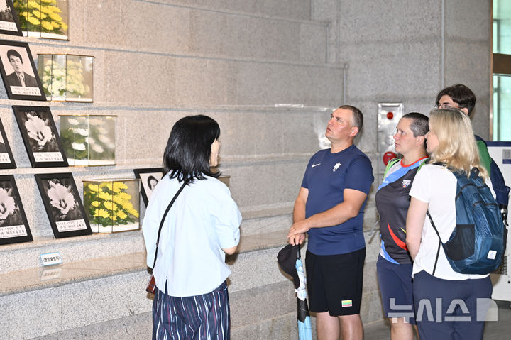 [광주=뉴시스] 박기웅 기자 = 2025 광주현대세계양궁선수권대회 출전 선수단 대상 팸투어 프로그램에 참여한 리투아니아와 헝가리 선수단이 9일 오전 국립5·18민주묘지를 방문, 유영봉안소에서 가이드의 설명을 듣고 있다. 2025.09.09. pboxer@newsis.com