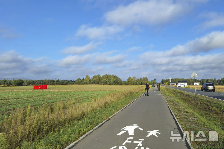 [AP/뉴시스] 10일 폴란드 방공망에 격추된 영공 침범 무인비행체가 비알라 포들라스카 한 곳에서 발견돼 빨간 포장막에 가려진 채 소방관이 지키고 있다 