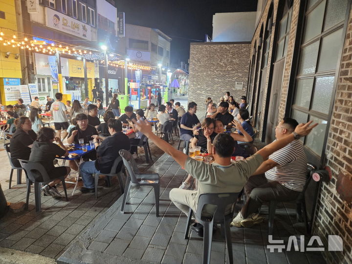 [포항=뉴시스] 송종욱 기자 = 포항중앙상가에서 지난달 14일 개장 이후 매주 금토일 다양한 테마로 운영한 '영일만친구 야시장'에 한 달간 10만명의 방문객이 다녀가며 구도심에 활력을 불어넣었다. 사진은 '영일만친구 야시장' 먹거리 부스 방문객 모습. (사진=포항시 제공) 2025.09.11. photo@newsis.com