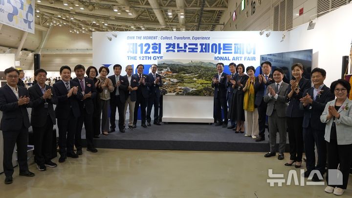 [창원=뉴시스]11일 오후 경남 창원컨벤션센터에서 '제12회 경남국제아트페어(GIAF 2025)' 개막식 참석자들이 가림천을 걷어낸 후 기념촬영하고 있다.(사진=경남도 제공) 2025.09.11. photo@newsis.com