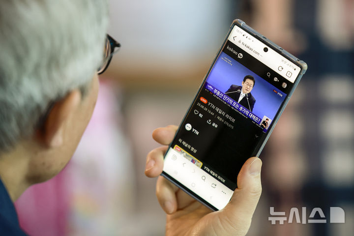 [서울=뉴시스] 정병혁 기자 = 11일 서울 중구 서울역에서 한 시민이 휴대폰을 통해 이재명 대통령 취임 100일 기자회견을 시청하고 있다. 2025.09.11. jhope@newsis.com