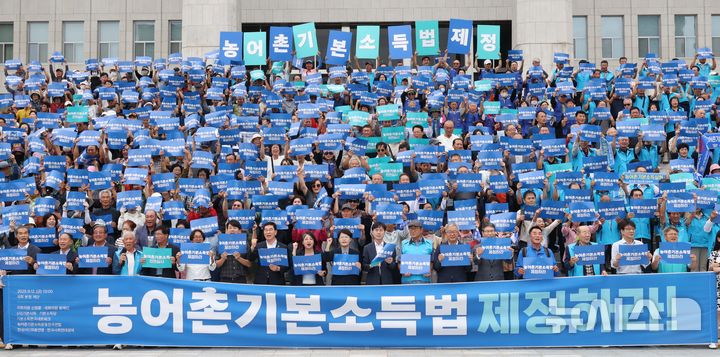 [서울=뉴시스] 조성봉 기자 = 지난달 12일 오후 서울 여의도 국회 본청 앞 계단에서 열린 농어촌기본소득법 제정 촉구 기자회견에서 참가자들이 손피켓을 들고 구호를 외치고 있다.2025.09.12. suncho21@newsis.com