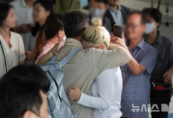 [인천공항=뉴시스] 황준선 기자 = 이민 단속으로 체포됐던 미국 현대차-LG엔솔 배터리공장 건설 현장 직원이 12일 인천국제공항 제2터미널로 귀국한 뒤 장기주차장에서 대기 중이던 가족과 만나 포옹하고 있다. (공동취재) 2025.09.12. photo@newsis.com