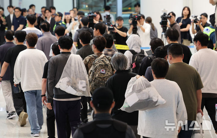 [인천공항=뉴시스] 황준선 기자 = 미국 이민당국에 의해 조지아주에 구금됐던 한국인 근로자들이 12일 영종도 인천국제공항 제2여객터미널 입국장을 나서고 있다. (공동취재) 2025.09.12. photo@newsis.com