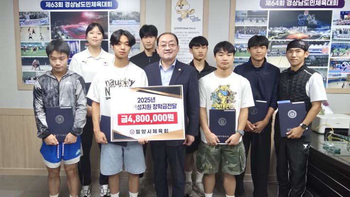 [밀양=뉴시스] 민경갑 체육회장이 지역 초·중학교를 졸업한 체육 꿈나무 8명에게 장학금을 전달하고 기념촬영을 하고 있다. (사진=밀양시체육회 제공) 2025.09.13. photo@newsis.com *재판매 및 DB 금지